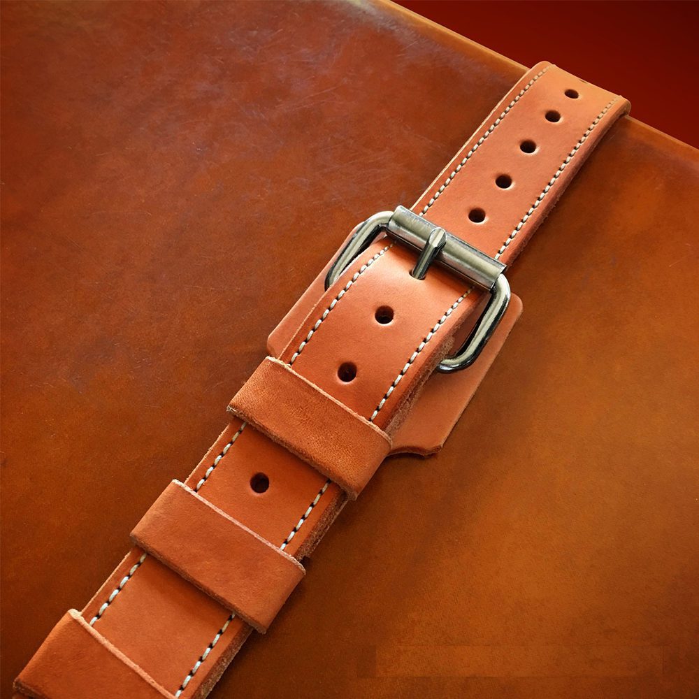 Leather securing strap with metal buckle